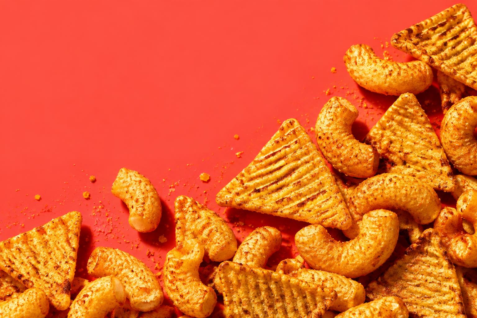 Golden protein chips and puffs on a bright red surface